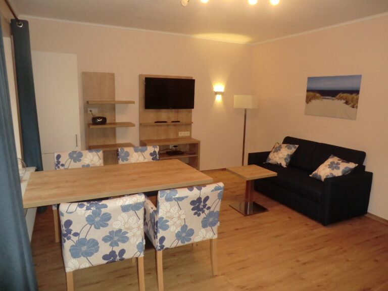 Gemütliches Wohnzimmer mit Essbereich, Couch und moderner Ausstattung in Ferienwohnung Brak.