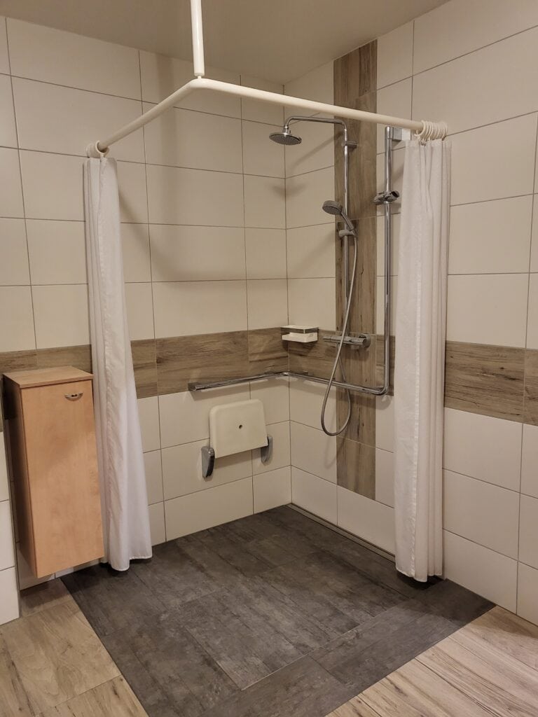 Barrierefreie Dusche mit Haltegriffen und Duschsitz.