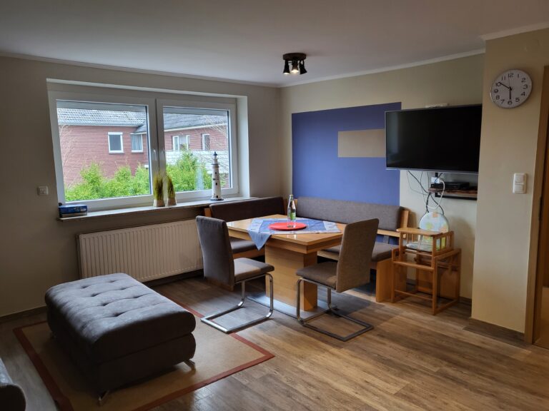 Ferienwohnung Brake mit modernem Wohnzimmer und Blick auf den Garten.