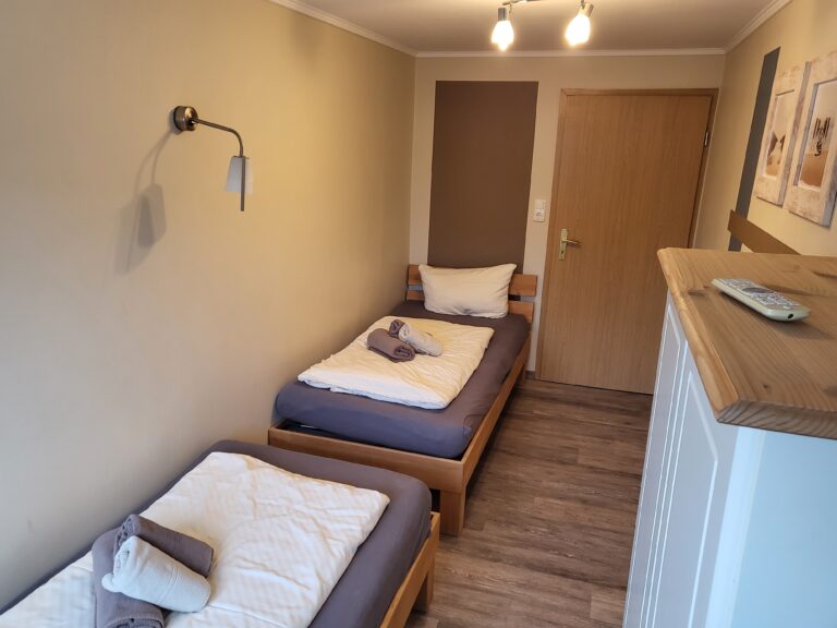 Schlafzimmer in Ferienwohnung Brak mit zwei Betten, moderner Einrichtung und angenehmer Atmosphäre.