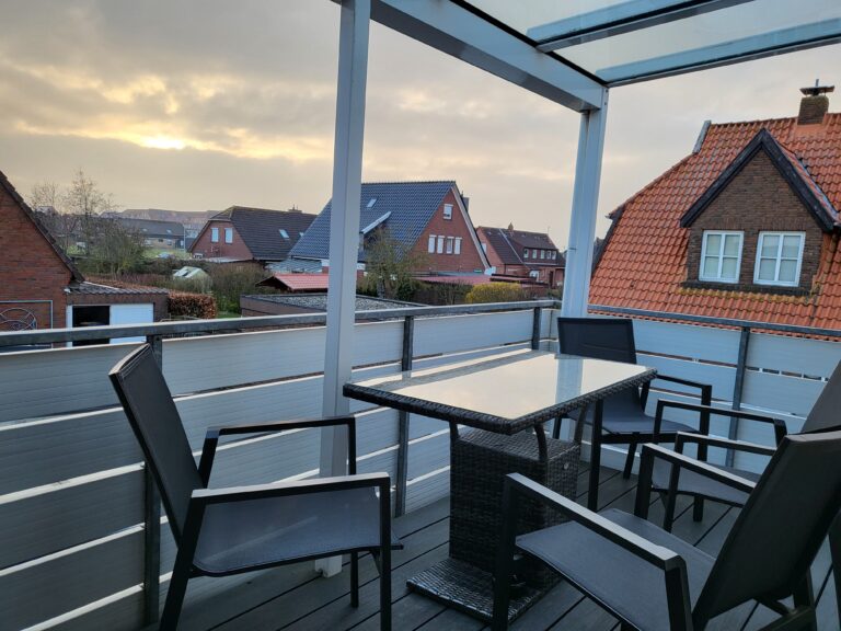 Balkon mit Sitzgelegenheiten und Blick auf das Dorf in Ferienwohnung Brak.