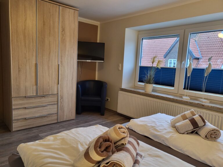 Ferienwohnung Schlafzimmer mit Doppelbett, Blick auf den Garten, gemütliche Einrichtung, ideal für U.