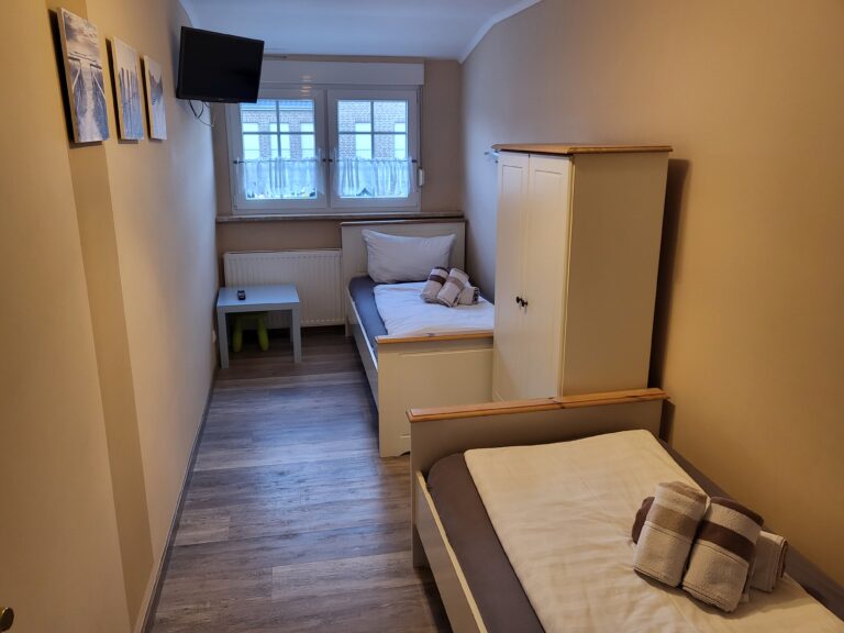 Ferienwohnung Brake mit zwei Betten, TV und komfortabler Einrichtung für einen angenehmen Aufenthalt.