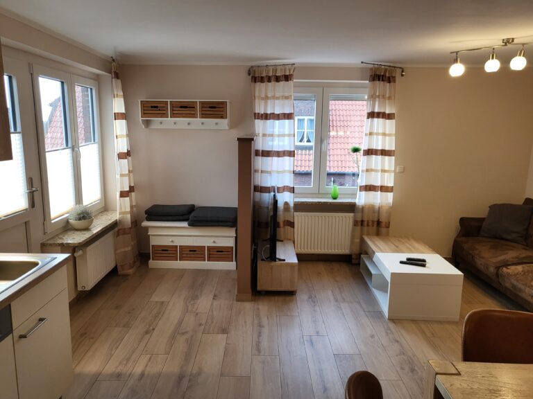 Ferienwohnung Brake, gemütliches Wohnzimmer, helle Einrichtung, ruhige Lage, ideal für Urlaub und Ku.
