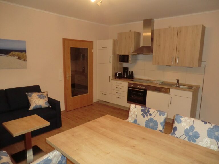 Gemütliche Ferienwohnung mit Küchenzeile, Essbereich und Blick auf den Wohnraum in Brak.