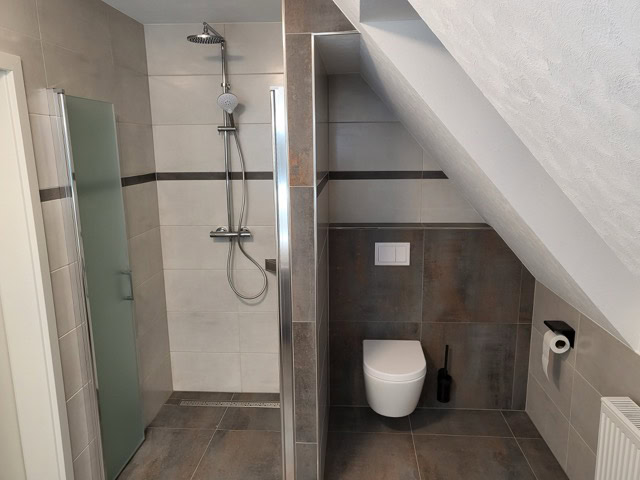 Moderne Badezimmer in Ferienwohnungen in Brake, inklusive Dusche und WC.