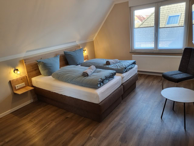 Schlafzimmer mit Doppelbett, gemütliche Einrichtung, viel Tageslicht, ideal für Ferienwohnungen in B.