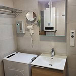 Helles Badezimmer in Ferienwohnung mit Waschmaschine und Heizkörper.