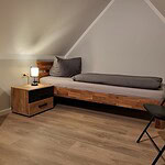 Gemütliches Einzelzimmer mit Bett, Nachttisch und Leselampe in Ferienwohnung Brak.