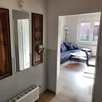 Eingangsbereich mit Flur und Blick ins Wohnzimmer in Ferienwohnungen Brak, gemütlich eingerichtet.