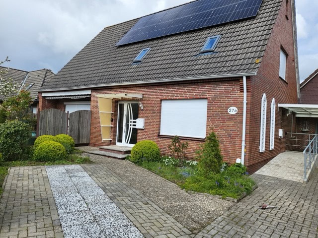 Modernes Ferienhaus in Brake mit Solarzellen auf dem Dach, Garten und Parkplatz.