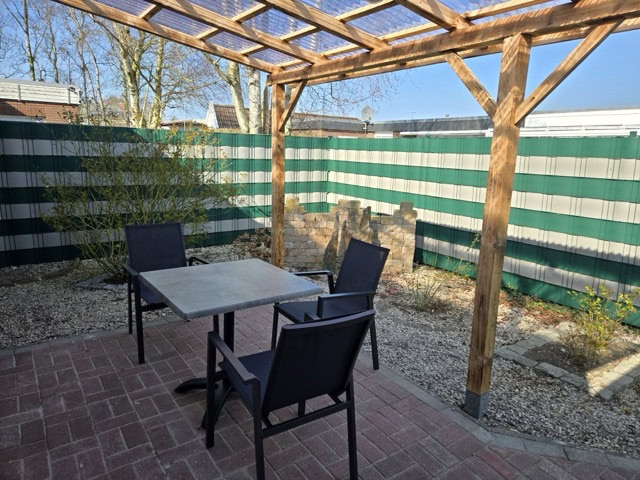 Außenbereich mit Gartenmöbeln, Holzpergola und privatem Garten in Ferienwohnungen Brak.