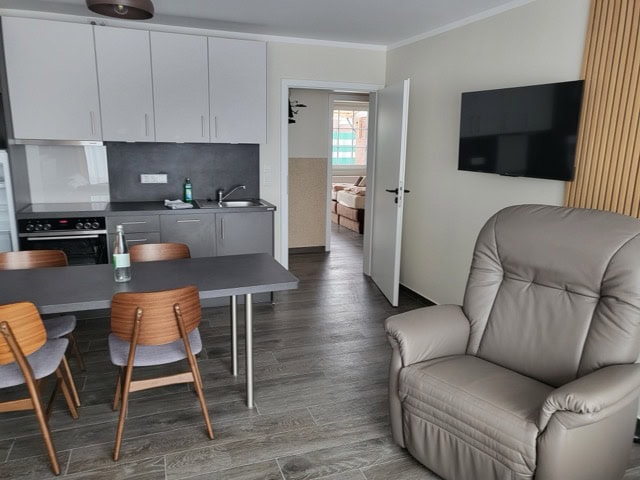 Modern eingerichtete Ferienwohnung in Brake mit Küche, Essbereich und gemütlichem Wohnzimmer.